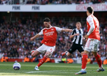 Declan Rice shoots with a Newcastle player in the background