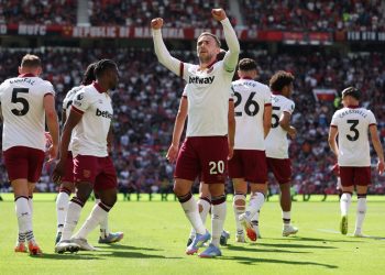 Jarrod Bowen celebrates during the Manchester United vs West Ham clash at Old Trafford after scoring, surrounded by teammates in white away kits.