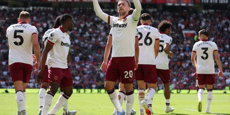 Jarrod Bowen celebrates during the Manchester United vs West Ham clash at Old Trafford after scoring, surrounded by teammates in white away kits.