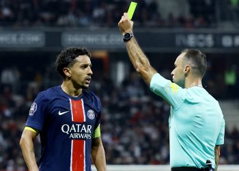 Paris St Germain's Marquinhos is shown a yellow card by referee Jerome Brisard (Reuters)