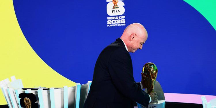 FIFA president Gianni Infantino holds the World Cup trophy after the playoffs draw (Reuters)